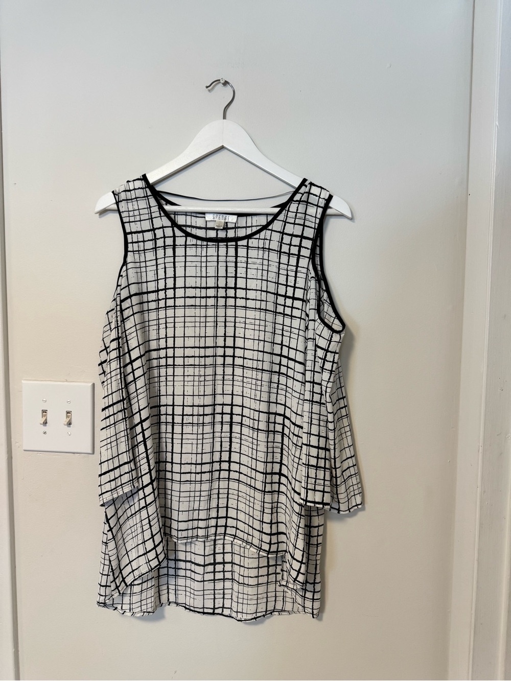 Black and white plaid blouse with cutouts and 3/4-length sleeves.